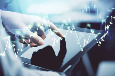 Multi exposure of mans hands holding and using a phone and financial chart drawing. Market analysis...