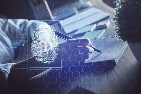 Blue fingerprint hologram over hands taking notes background. Concept of security. Double exposure