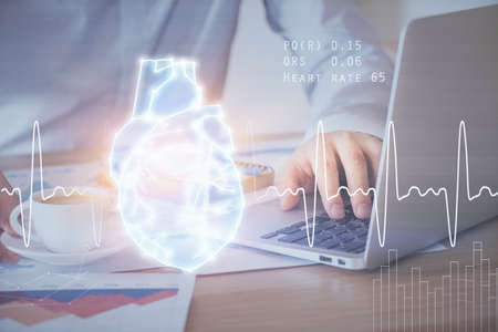 Heart drawing with man working on computer on background. Medical concept. Double exposure.