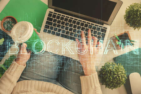 Double exposure of woman hands working on computer and blockchain theme hologram drawing. Top View....