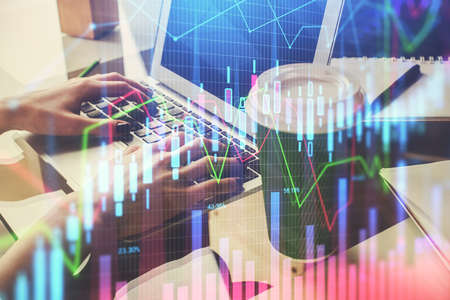 Double exposure of woman hands typing on computer and forex chart hologram drawing. Stock market...