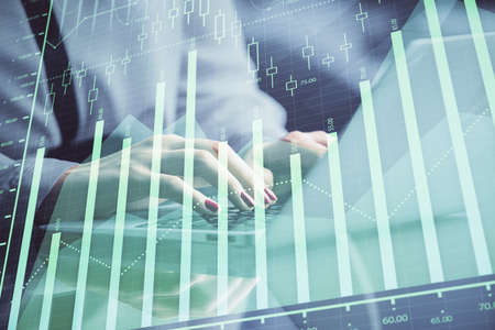 Double exposure of businesswoman hands typing on computer and forex chart hologram drawing....