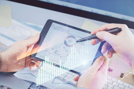 Double exposure of mans hands holding and using a phone and financial chart drawing. Market analysis...