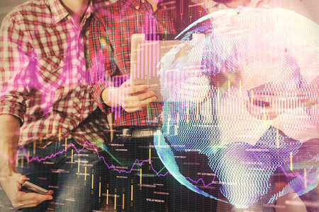 Double exposure of forex graph drawing and man and woman working together holding and using a mobile...