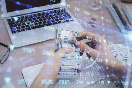 Multi exposure of financial graph drawing hologram and USA dollars bills and man hands. Analysis...