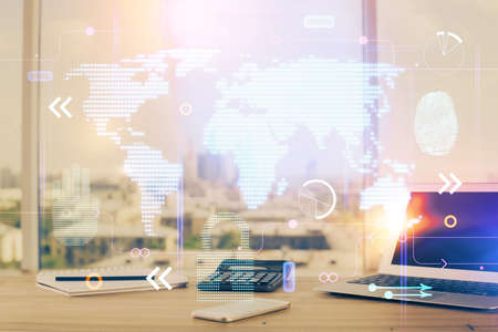 Double exposure of desktop with computer and world map hologram. International data network concept.