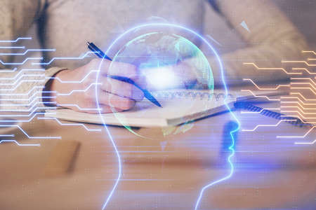 Double exposure of woman's writing hand on background with brain hud. Concept of learning.