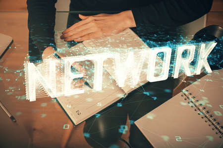 Double exposure of writing hands on background with data solution hologram on front. Technology...