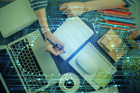 Double exposure of hands making notes with digital coding icons. Computer learning concept.
