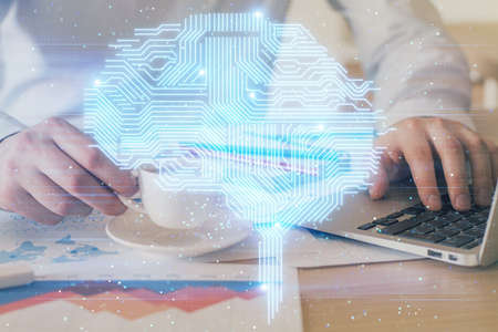 Businessman with computer background with brain theme hologram. Concept of brainstorm. Multi...