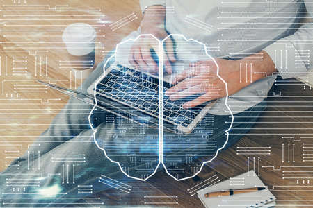 Businessman with computer background with brain theme hologram. Concept of brainstorm. Multi...