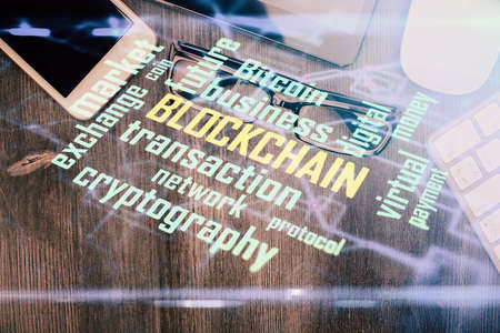 Double exposure of blockchain theme hologram over table with phone. Top view. Crypto technology...