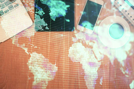 Double exposure of business theme hologram over desktop with phone. Top view. Mobile international...