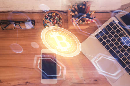 Double exposure of blockchain theme hologram over table with phone. Top view. Crypto technology...