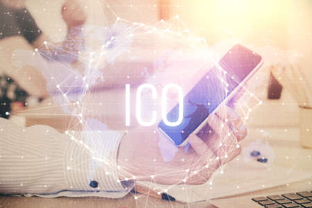 Double exposure of man's hands holding and using a phone and crypto currency blockchain theme...