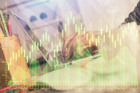 Double exposure of woman hands typing on computer and forex chart hologram drawing. Stock market...