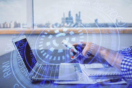 Double exposure of man's hand holding and using a digital device and data theme hologram drawing....