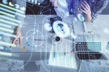 Double exposure of man and woman working together and data theme hologram drawing. Computer...