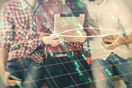 Double exposure of forex graph drawing and man and woman working together holding and using a mobile...