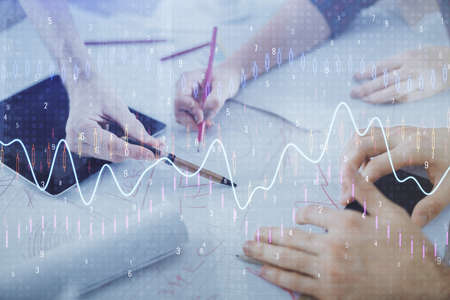 Double exposure of forex graph drawing and man and woman working together holding and using a mobile...