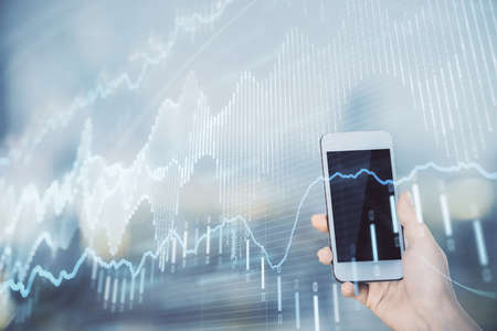 Double exposure of forex chart sketch hologram and woman holding and using a mobile device. Stock...