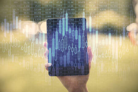 Double exposure of forex chart sketch hologram and woman holding and using a mobile device....