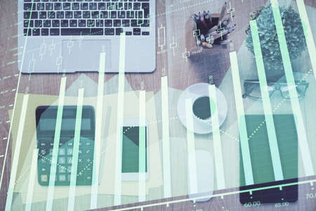Double exposure of forex chart hologram over desktop with phone. Top view. Mobile trade platform...