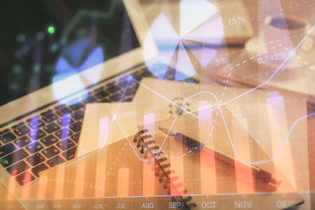 Double exposure of financial chart drawing and desktop with coffee and items on table background. Concept of forex market tradingの写真素材