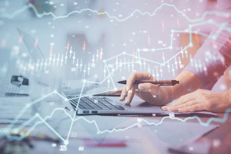 Multi exposure of woman hands typing on computer and financial chart hologram drawing. Stock market...