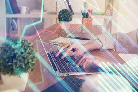 Double exposure of woman hands typing on computer and forex chart hologram drawing. Stock market...