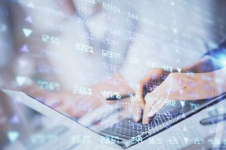 Double exposure of woman hands typing on computer and forex chart hologram drawing. Stock market invest concept.の写真素材