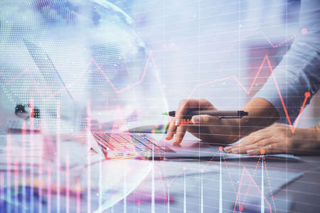 Double exposure of woman hands typing on computer and forex chart hologram drawing. Stock market...