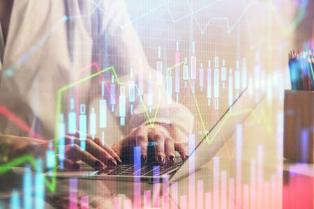 Double exposure of woman hands typing on computer and forex chart hologram drawing. Stock market...