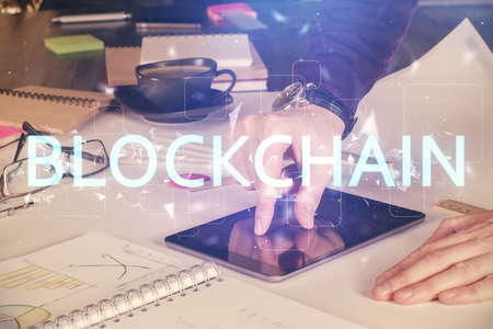 Double exposure of man's hands holding and using a phone and crypto currency blockchain theme...