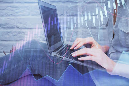 Multi exposure of woman hands typing on computer and forex chart hologram drawing. Stock market...