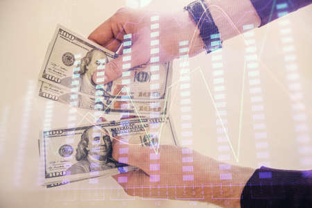 Multi exposure of financial graph drawing hologram and USA dollars bills and man hands. Analysis concept.の写真素材