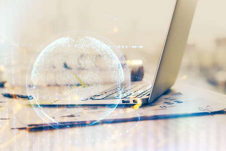 Double exposure of desktop with computer and world map hologram. International data network concept.の写真素材