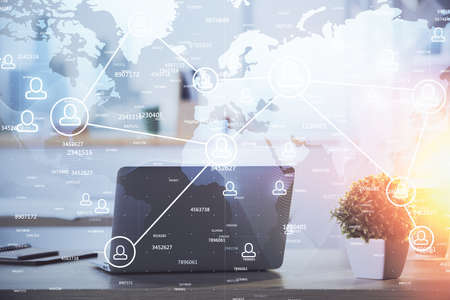 Computer on desktop with social network hologram. Double exposure. Concept of international people connections.の写真素材