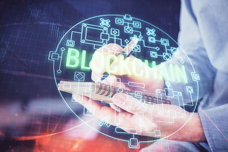 Man's hands working with notes background. Cryptocurrency and finance concept. Double exposure.