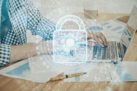Double exposure of lock icon with man working on computer on background. Concept of network...