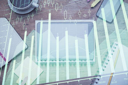 Double exposure of forex chart hologram over desktop with phone. Top view. Mobile trade platform...
