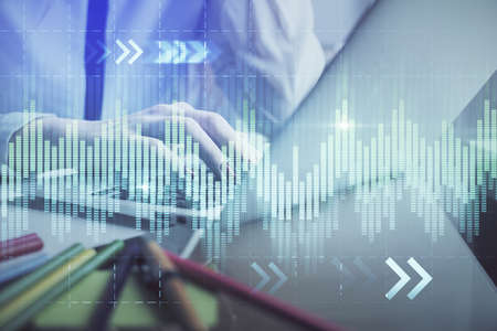Double exposure of woman hands typing on computer and financial graph hologram drawing. Stock market...