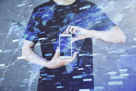 Double exposure of man's hand holding and using a digital device and data theme hologram drawing....
