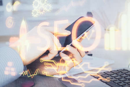 Multi exposure of man's hands holding and using a digital device and seo drawing. search...