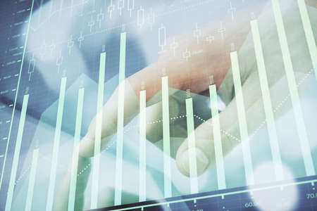 Multi exposure of man's hands holding and using a phone and financial chart drawing. Market analysis...