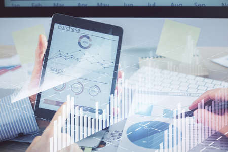Multi exposure of man's hands holding and using a phone and financial chart drawing. Market analysis...