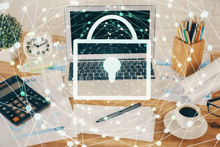 Double exposure of desktop with computer and lock icon hologram. Concept of data safety.の写真素材