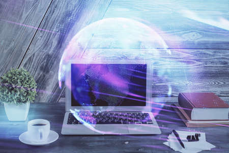 Computer on desktop in office with technology theme hologram. Double exposure. Tech concept.の写真素材
