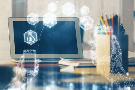 Computer on desktop in office with technology theme hologram. Multi exposure. Tech concept.