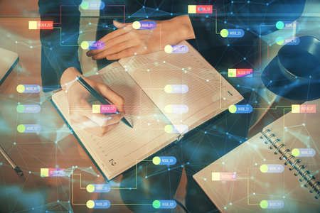 Double exposure of writing hands on background with data solution hologram on front. Technology concept. TOP view.の写真素材